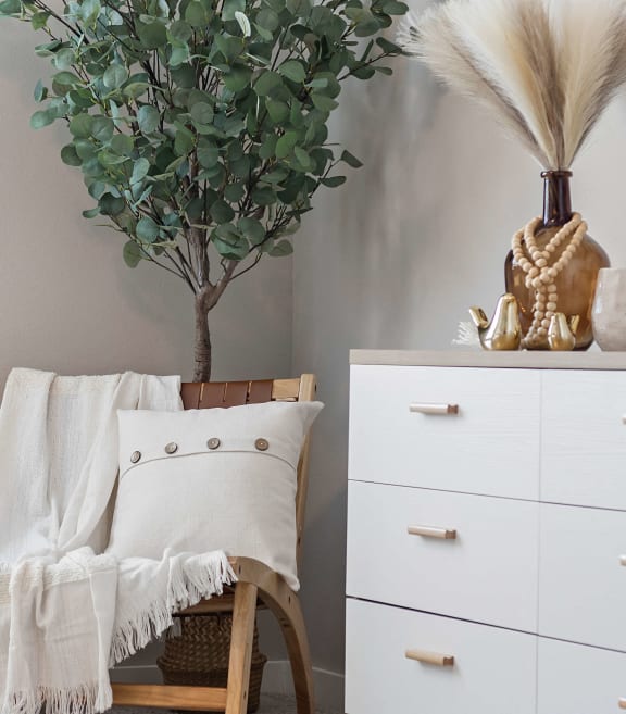a living room with a chair and a white dresser and a plantat Hillcrest Village, Springdale, AR 72762
