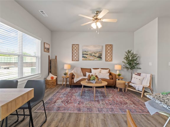 an open living room with couches and a table and a ceiling fanat Hillcrest Village, Springdale, AR 72762