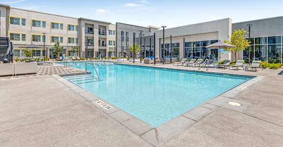 A large outdoor swimming pool in front of a building.