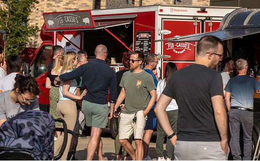 A group of people are standing in front of a red food truck.at Penny Green Apartments, St Neots, WINTRINGHAM