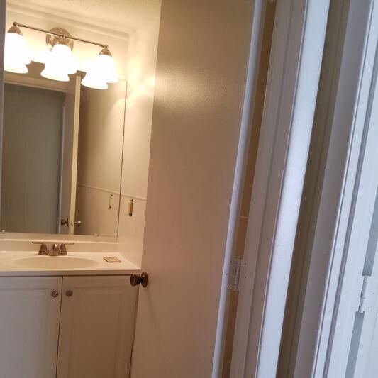 A white bathroom with a sink and mirror.