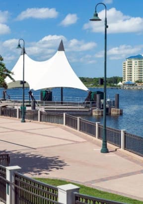 a pier with a white canopy and a building in the background