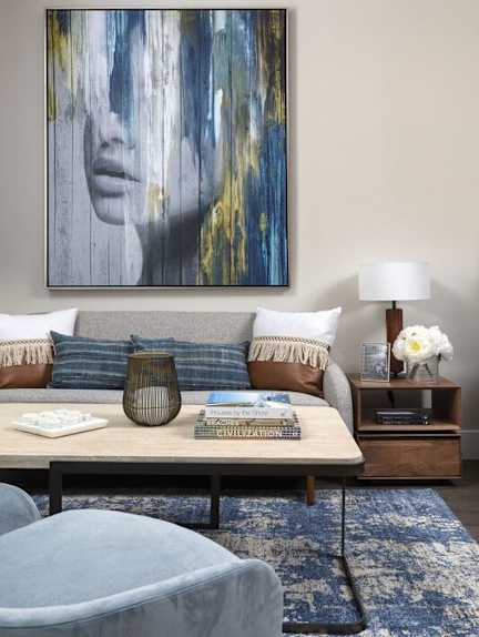 A living room with a blue rug and a grey armchair.