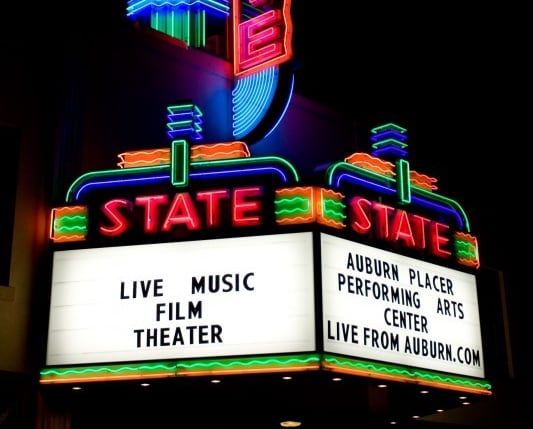 A brightly lit State Theatre sign at night.