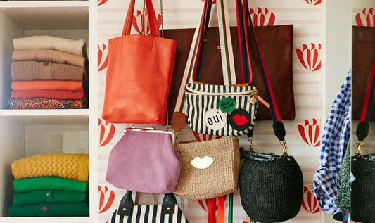 a closet filled with purses and totes and clothes