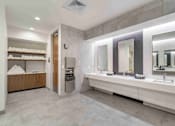 Thumbnail 20 of 24 - A bathroom with a vanity, mirrors, and a towel rack.
