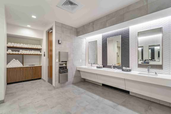 A bathroom with a vanity, mirrors, and a towel rack.
