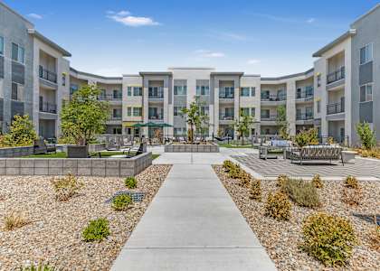 A concrete walkway leads through a courtyard surrounded by apartment buildings.