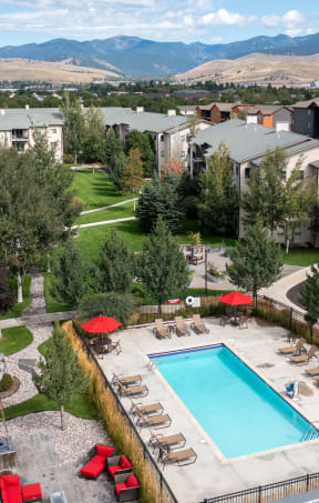 an aerial view of the resort style pool with lounge chairs and umbrellas Mullan Reserve Apartments, Missoula, MT