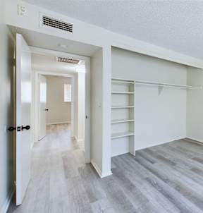 A room with a white door and a grey floor.