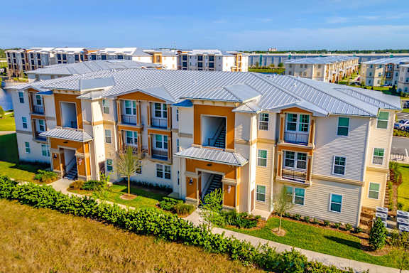 an aerial view of an apartment building with a green lawn