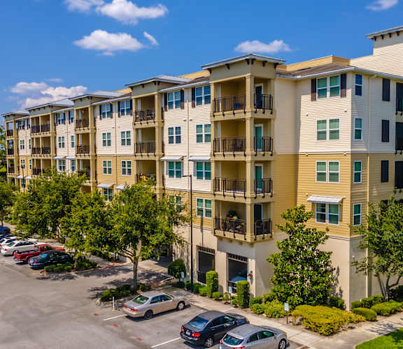 an aerial view of an apartment complex with a parking lot