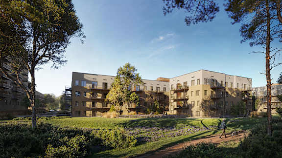 A modern apartment building with balconies and a person walking on the sidewalk.