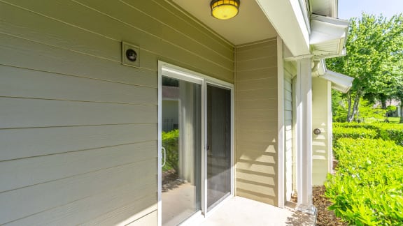 a covered walkway leading to a house with glass doors