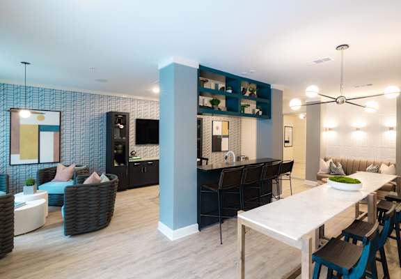 A modern living room with a dining area and kitchen in the background at Hudson at Renaissance Apartments, North Carolina 28405