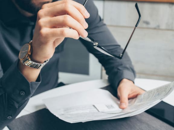 a close up of a person signing a document with a pencil