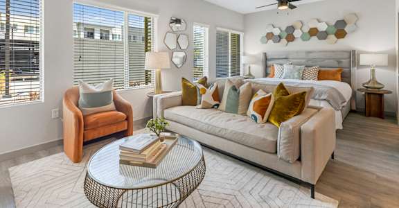 A well-lit, modern living room with a sofa, armchair, and a coffee table.