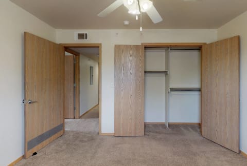 a bedroom with two closets and a ceiling fan