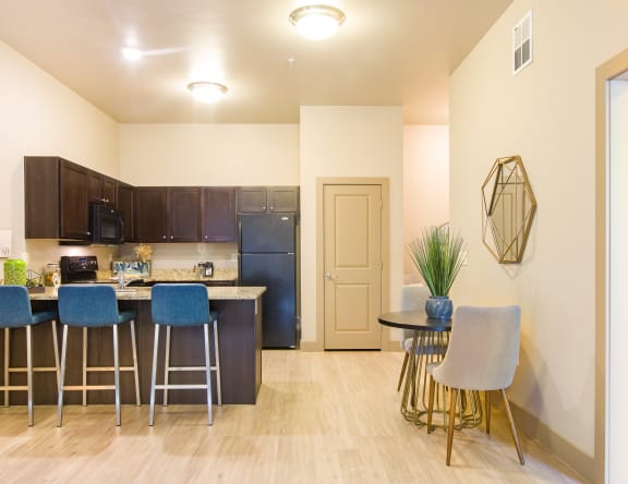 A kitchen with a bar area and a dining table at Sugar House Apartments By Urbana, Salt Lake City, UT, 84105