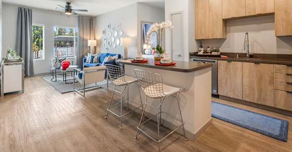 A modern kitchen with a dining area and a living room.