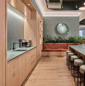 A modern kitchen with wooden cabinets and a bar area.