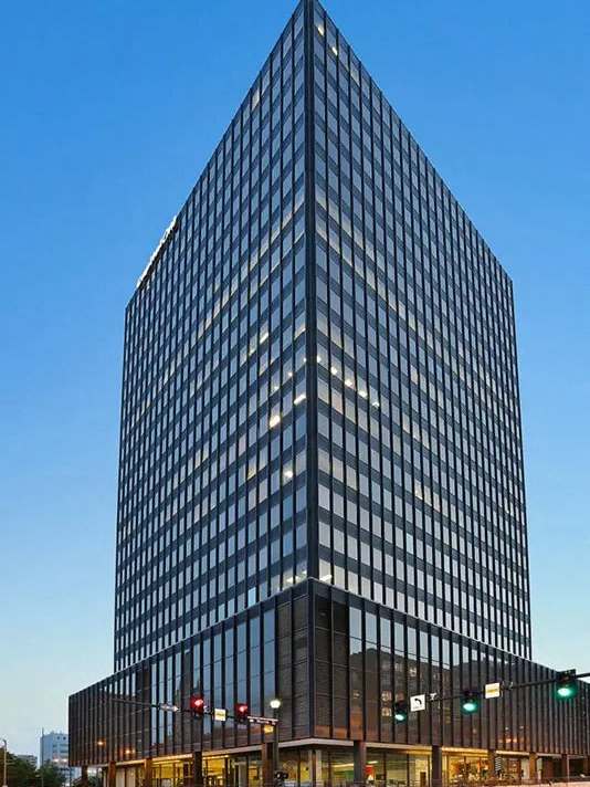 a tall office building on the corner of a city street