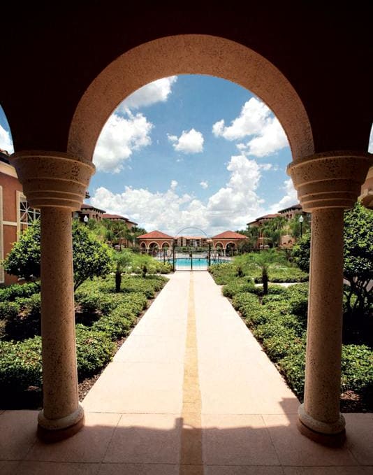 a view of a courtyard with columns and a pool