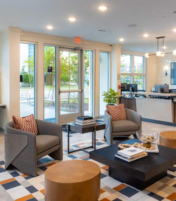 A modern living room with a stone fireplace and a large open space at Waterleaf at Neely Ferry Apartments, Simpsonville, SC