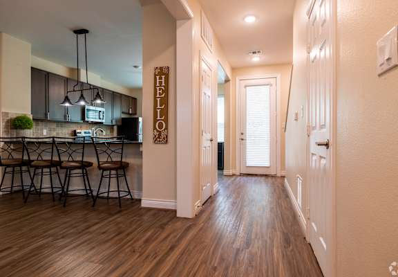 A hallway with a wooden floor and a sign that says "HELLO" on the wall.