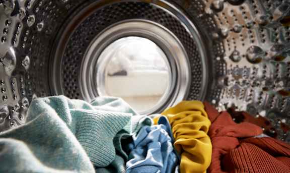 a washing machine with clothes in front of a window