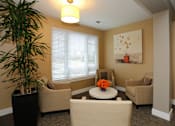 Thumbnail 11 of 31 - A living room with a large painting on the wall and a potted plant on the left.