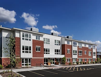 A large red and white building with a parking lot in front.