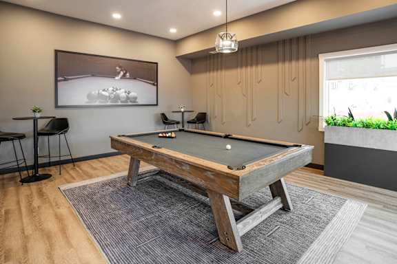 A pool table in a room with a painting on the wall.
