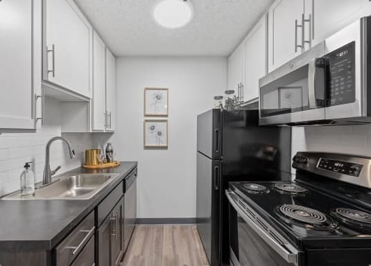 a kitchen with a stove and a microwave and a sink