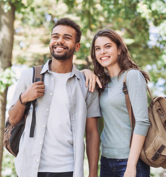 portrait of a young couple with backpacks walking in the city free photo