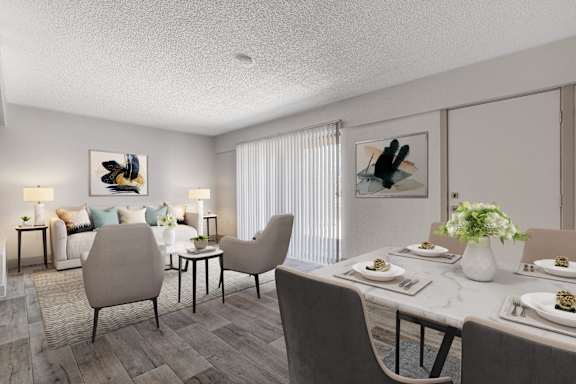 A dining room with a table set for two and a couch with a blue pillow.