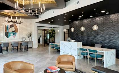 a lobby with chairs and tables and a reception desk