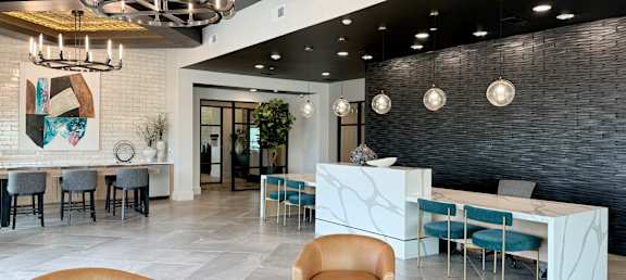 a lobby with chairs and tables and a reception desk