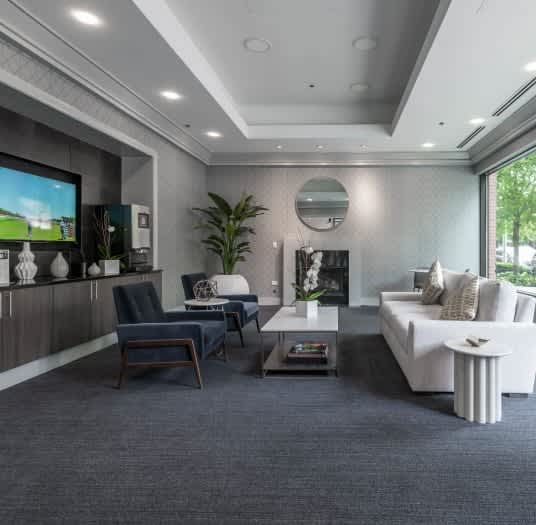 A modern living room with a dark blue carpet and a variety of furniture.