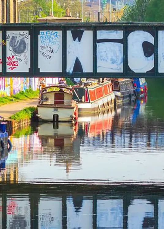 a group of boats docked on a river under a bridge