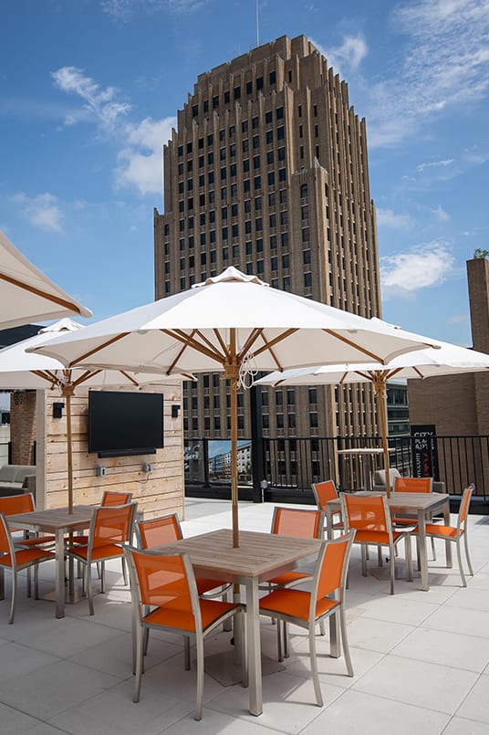 A patio with orange chairs and a white umbrella at The Gallery Apartment Homes Apartments, Allentown, PA, 18101