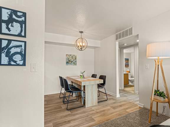 A dining room with a table and chairs.