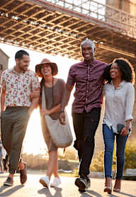 a group of people walking under the brooklyn bridge