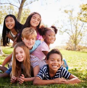 a group of kids laying in the grass  at Castlewood Apartments, Texas, 77531