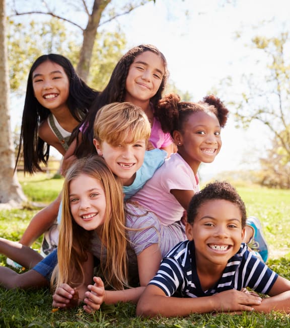 a group of kids laying in the grass at Oakridge Apartments, Antioch, 94509
