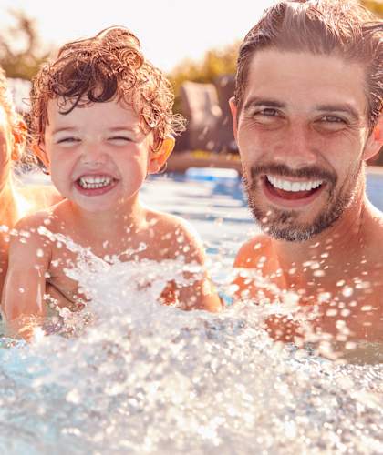 a man and woman with a child in a swimming pool