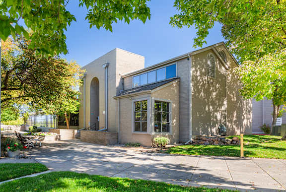 A modern house with a grey exterior and a large front yard.