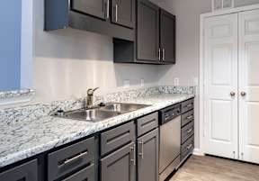 an empty kitchen with a sink and cabinets  at Lakeside on Riverwatch in Martinez, GA 30907