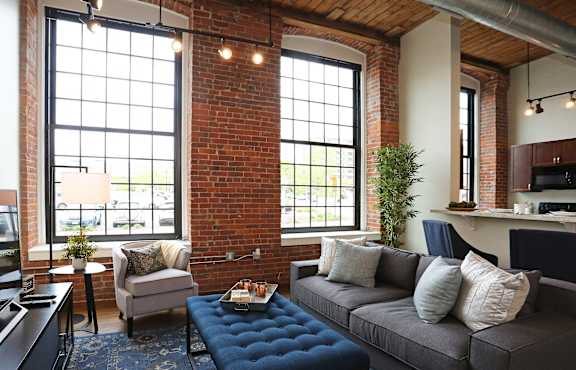 a living room with a gray couch and a large window