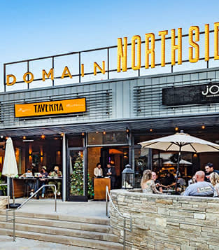 a restaurant with people sitting at tables outside of it